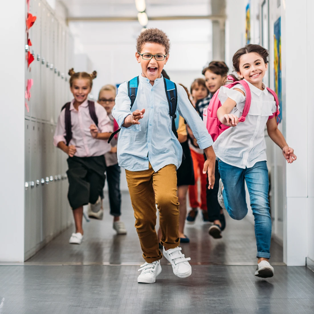 Kids running down school hallway